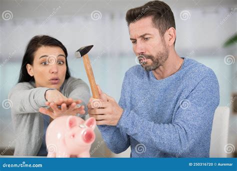 Woman Protecting Piggybank From Being Smashed By Husband With Hammer
