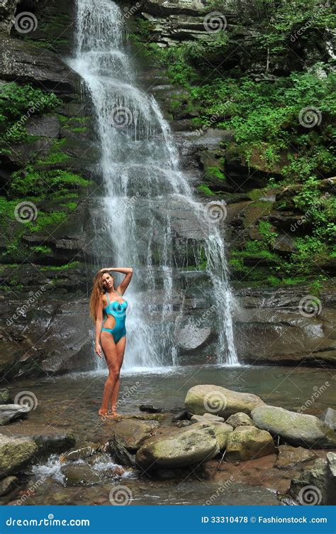 Beautiful Slim Fitness Model Posing Sexy In Front Of Waterfalls Royalty