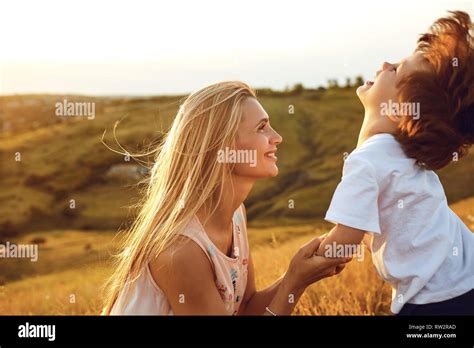 A Mother Kisses Her Son In Nature Stock Photo Alamy