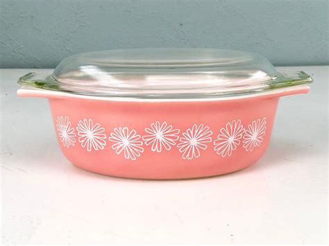 A Pink Casserole Dish With Flowers Painted On It