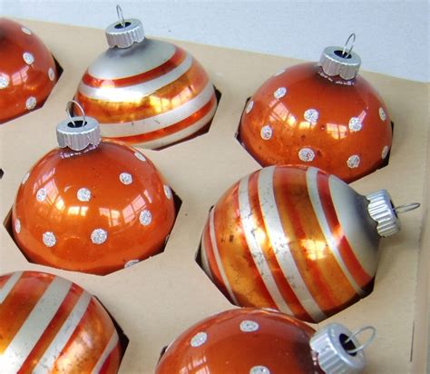 A sweet tree with blue, orange and red ornaments and bows ...