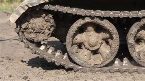 Caterpillar Tracks On War Tank Driving On Muddy Road Stock Footage