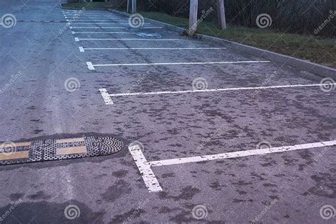 Parking Lot Of Gray Wet Asphalt With White Markings And Speed Bump
