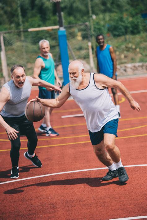 Interracial Elderly Sportsmen Playing Basketball Together On Free Stock