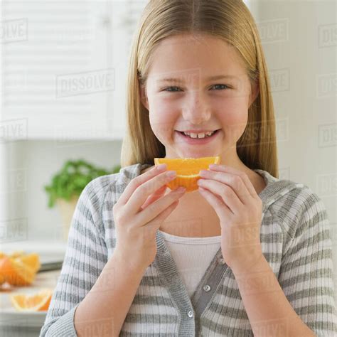 Girl Eating Orange Slice Stock Photo Dissolve