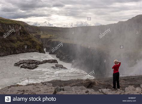 Tourist In The Edge Of The Gullfoss Falls Waterfall Located In The