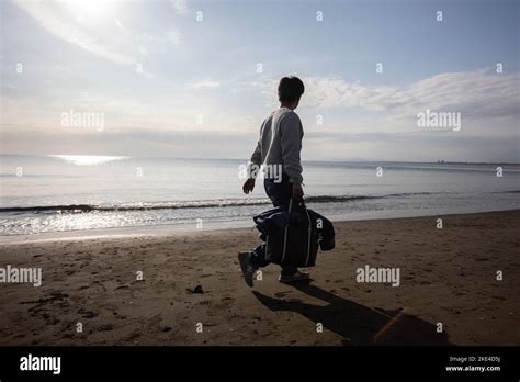 A man walks along Enoshima beach while carrying a bag. Enoshima beach