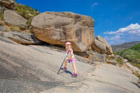 Adventuress Little Girl Posing With Trekking Sticks In Rocky Mountain
