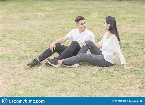 Loving Young Couple Sitting Down On Grass Stock Photo Image Of
