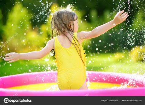 Маленькая девочка играет в надувном бассейне стоковое фото ©mnstudio