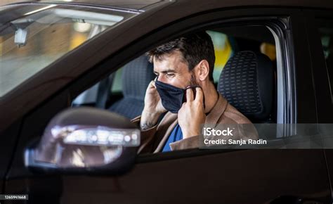 genç bir adam bir arabada oturur ve yüzüne bir maske koyar bir virüs neden olduğu bir salgın