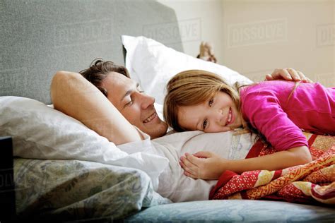 Daughter 6 7 Cuddling With Dad In Bed Stock Photo Dissolve