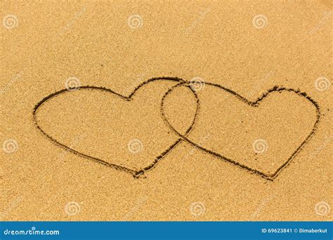 Two Entangled Hearts Drawn Out On A Sandy Beach Love Stock Image