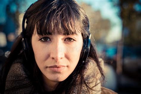 Mujer Joven Hermosa Que Escucha Los Auriculares De La Música Imagen De