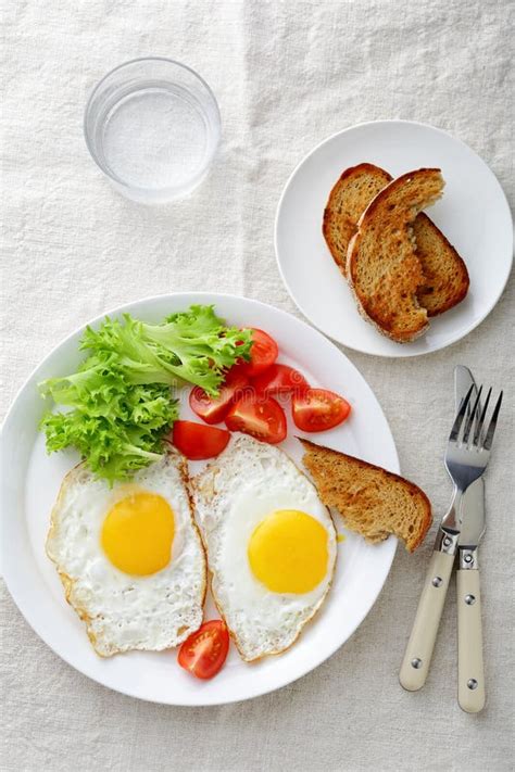 Breakfast Fried Eggs With Tomato Bread Lettuce And Glass Stock