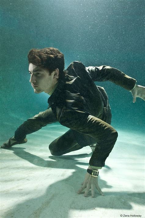 A Man In Black Suit Diving Under Water