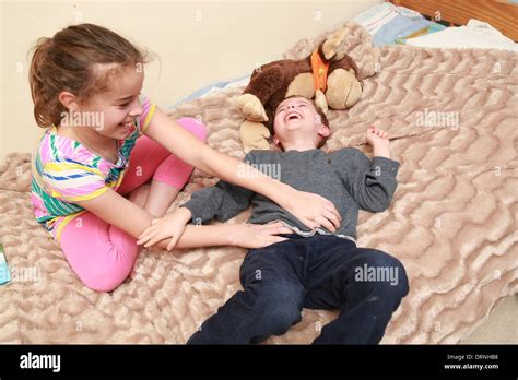 Sister Tickling Her Younger Brother Stock Photo Alamy