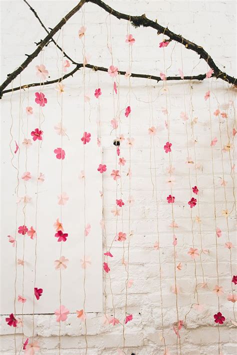 A White Wall With Pink And Red Flowers Hanging From Its Sides Next To