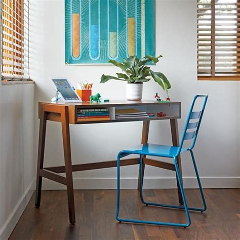 A Wooden Desk With A Blue Chair Next To It And A Painting On The Wall