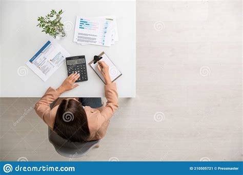 Overview Of Young Female Accountant Making Calculations And Writing