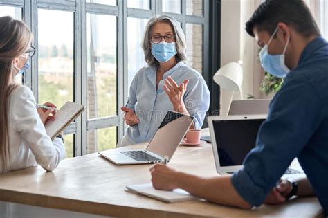 Pessoal De Equipe Usando Máscaras Médicas Durante Reunião No Escritório