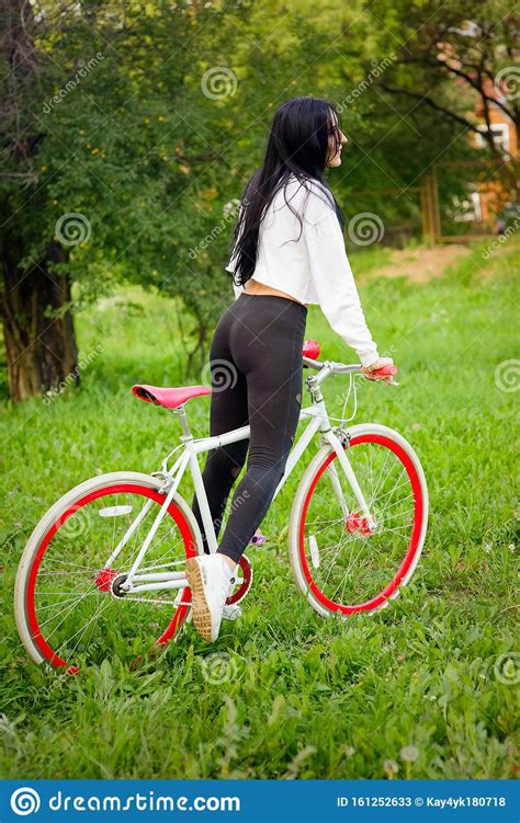 Girl On A Red And White Bike A Pretty Young Tanned Athletic Girl Rides