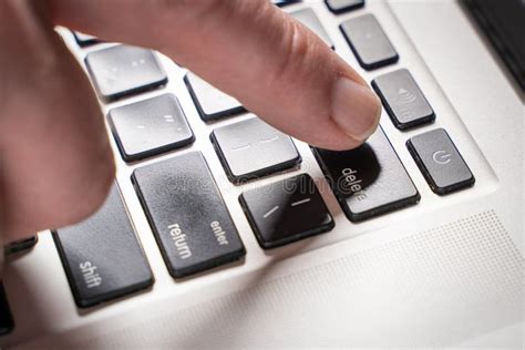 Finger Is Pressing Delete Key Of Computer Keyboard Close Up Top View