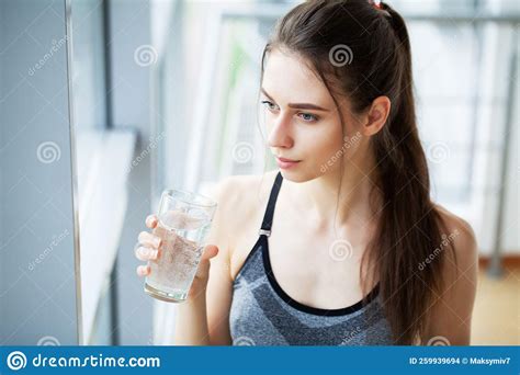 Sportive Woman Drinking Water From Bottle After Workout Stock Photo