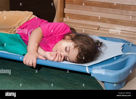 4 Year Old Preschool Girl Sleeping On A Cot During Naptime Stock Photo