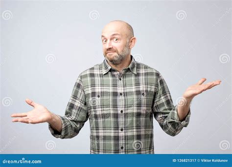 Portrait Of Confused Mature Man D Standing Over White Background