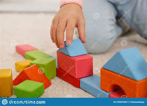 Cute Little Girl Playing With Colorful Building Blocks On Floor