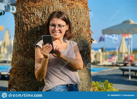 Happy Mature Woman With Smartphone Female Resting In Resort Spa Hotel