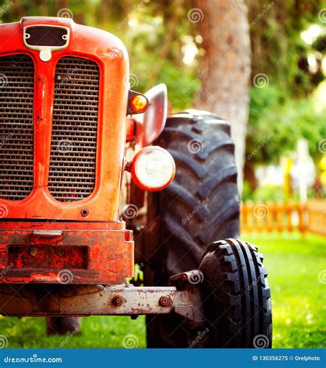 Old Vintage Red Tractor Standing On A Farm Field At Sunset Stock Image