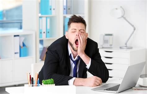 Premium Photo Yawning Tired Business Man Sitting At Workplace In Office