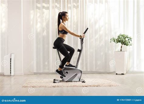 Young Woman Exercising On A Stationary Bike At Home Stock Image Image