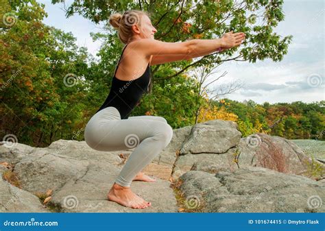 El Retrato De La Yoga Practicante Hermosa De La Mujer Joven Posiciones En Cuclillas Ejercita
