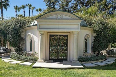 A Small White Building With An Arched Door