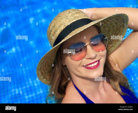 Portrait Of Woman Wearing Blue Bikini Sunglasses And Straw Hat Near