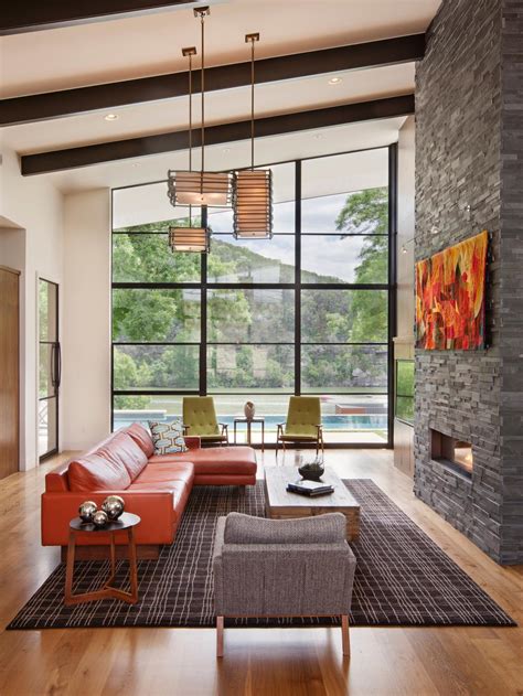 Contemporary living room with a sleek fireplace and a gray sofa supported by glass legs. Tips on Cleaning and Maintaining a Fireplace | DIY