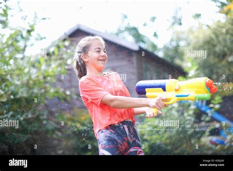 Teenage Girl Squirting Water Gun In Garden Stock Photo Alamy