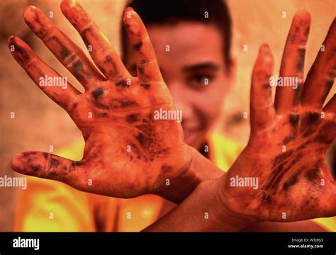 A Young Boy Is Displaying His Stained Hands Stock Photo Alamy