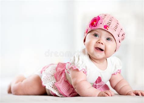 Pretty Smiling Baby Girl Lying On Stomach And Looking Up Stock Image