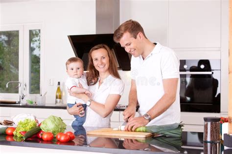 Семья дома в кухне стоковое фото изображение насчитывающей кашевар 20876052