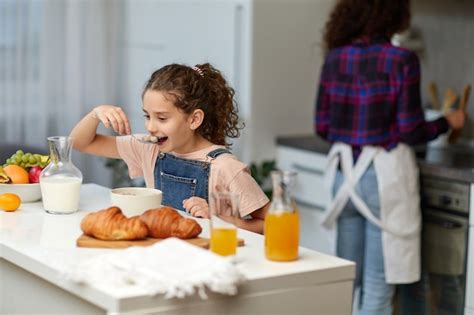 La Petite Fille Heureuse Mangeant Un Petit déjeuner Sain Aux Céréales