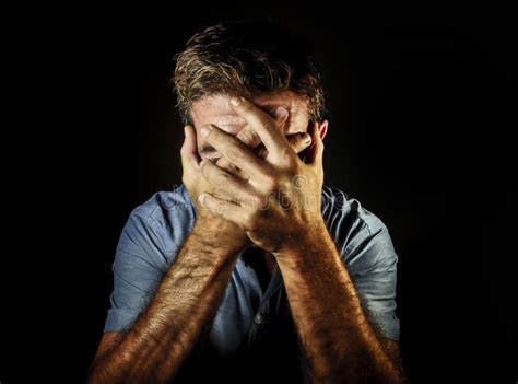 Dramatic Portrait Of Sad And Depressed Man Covering Face With Hands
