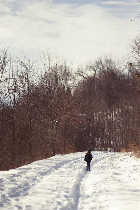 Young Boy Hiking On A Snow Covered Trail By Stocksy Contributor