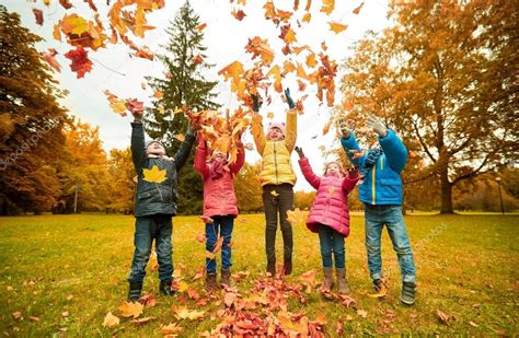 Happy Children Playing With Autumn Leaves In Park — Stock Photo © Syda