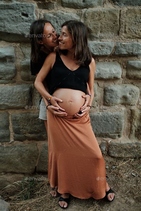 Vertical Closeup Of A Pregnant Lesbian Couple Doing A Photoshoot In A Park Stock Photo By Wirestock
