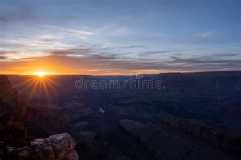 Purple Sunset With Orange Sunburst Over The Grand Canyon Stock Photo