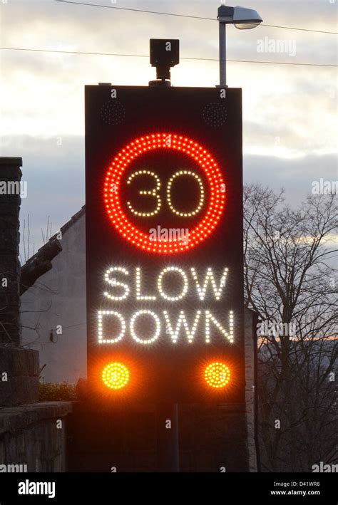 Slow Down Warning Roadsign Triggered By Approaching Vehicles At Dusk